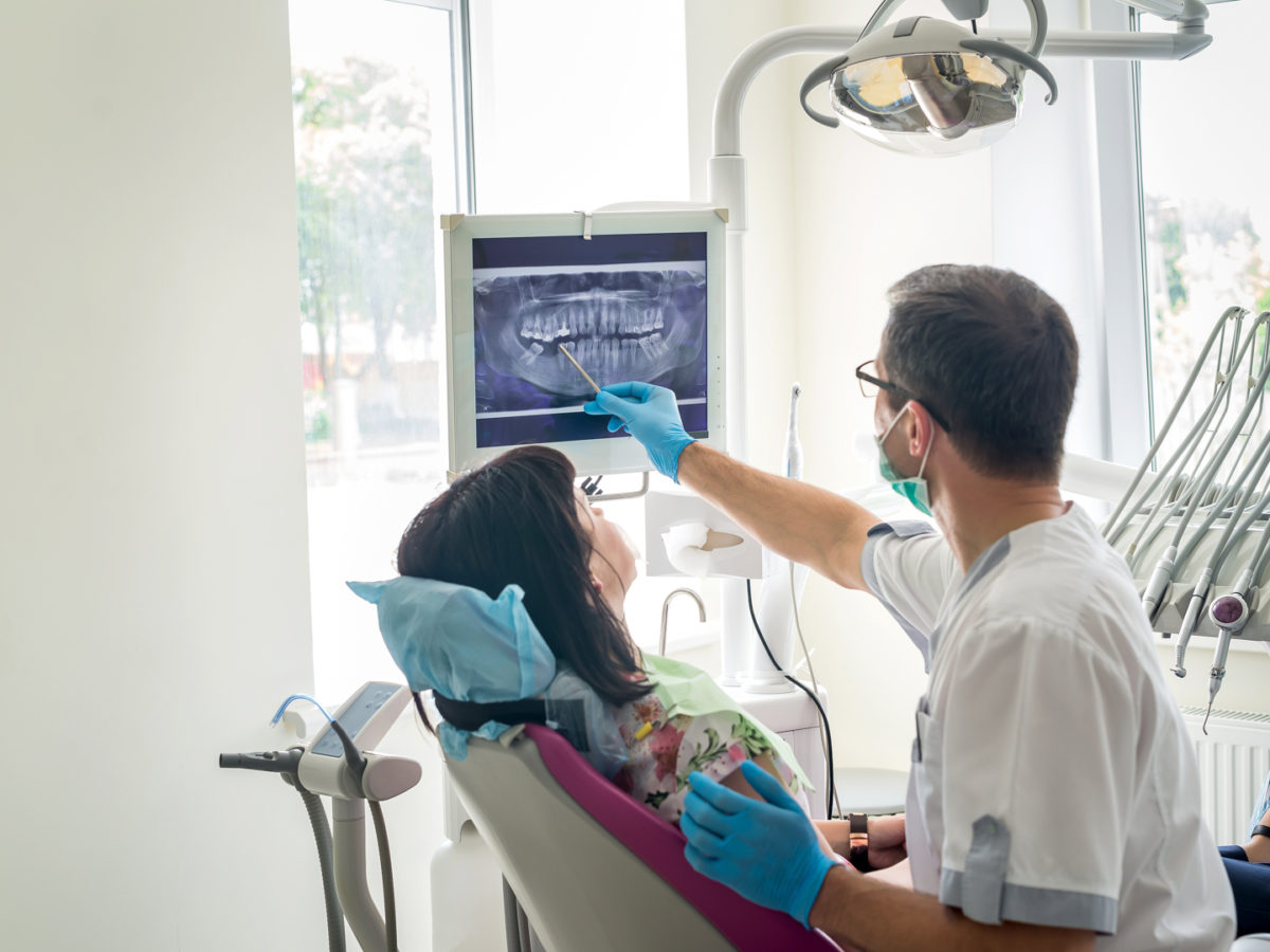 Doctor dentist showing patient's teeth on X-ray