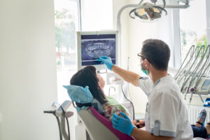 Doctor dentist showing patient's teeth on X-ray